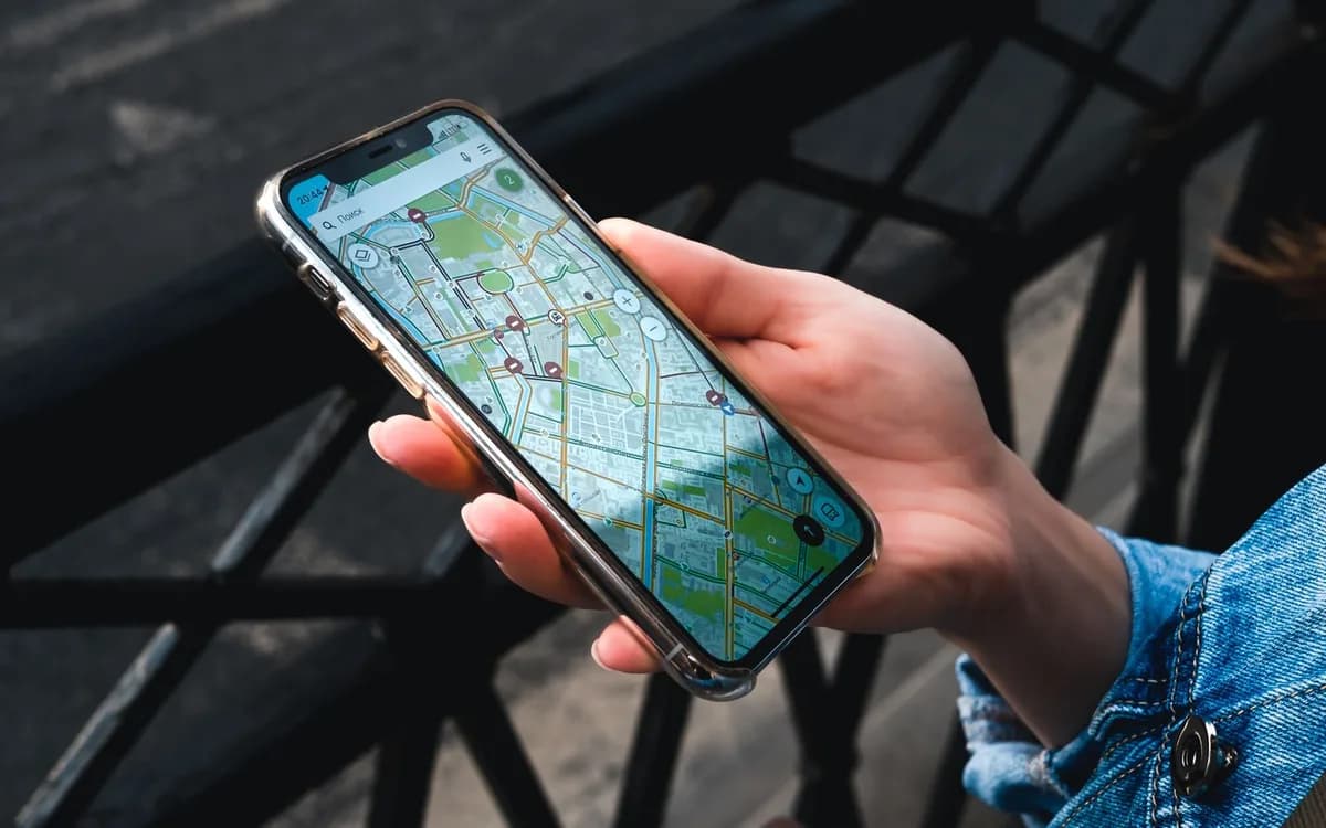 Pessoa consulta um mapa no celular; imagem ilustrativa de busca de localização.