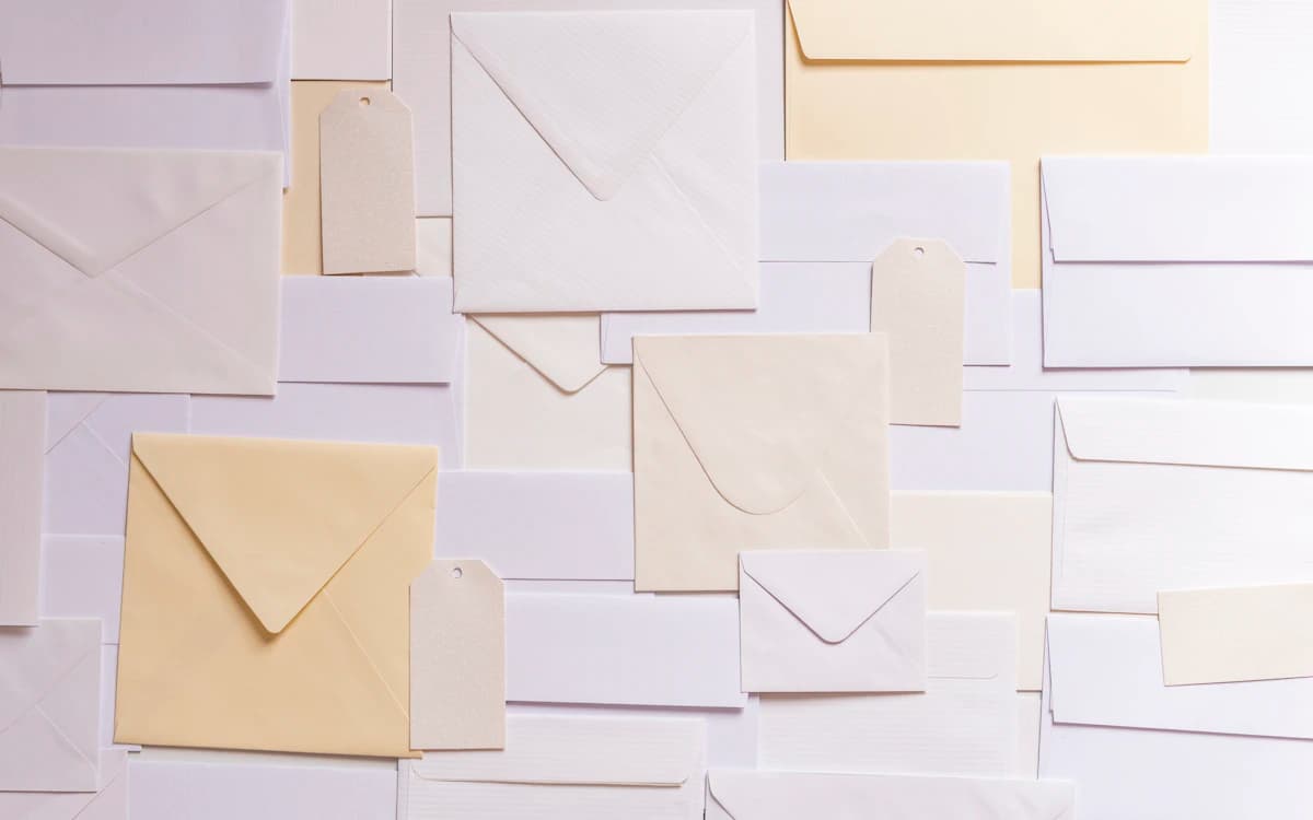 Envelopes de papel dispostos sobre uma superfície; imagem ilustrativa de correspondências.